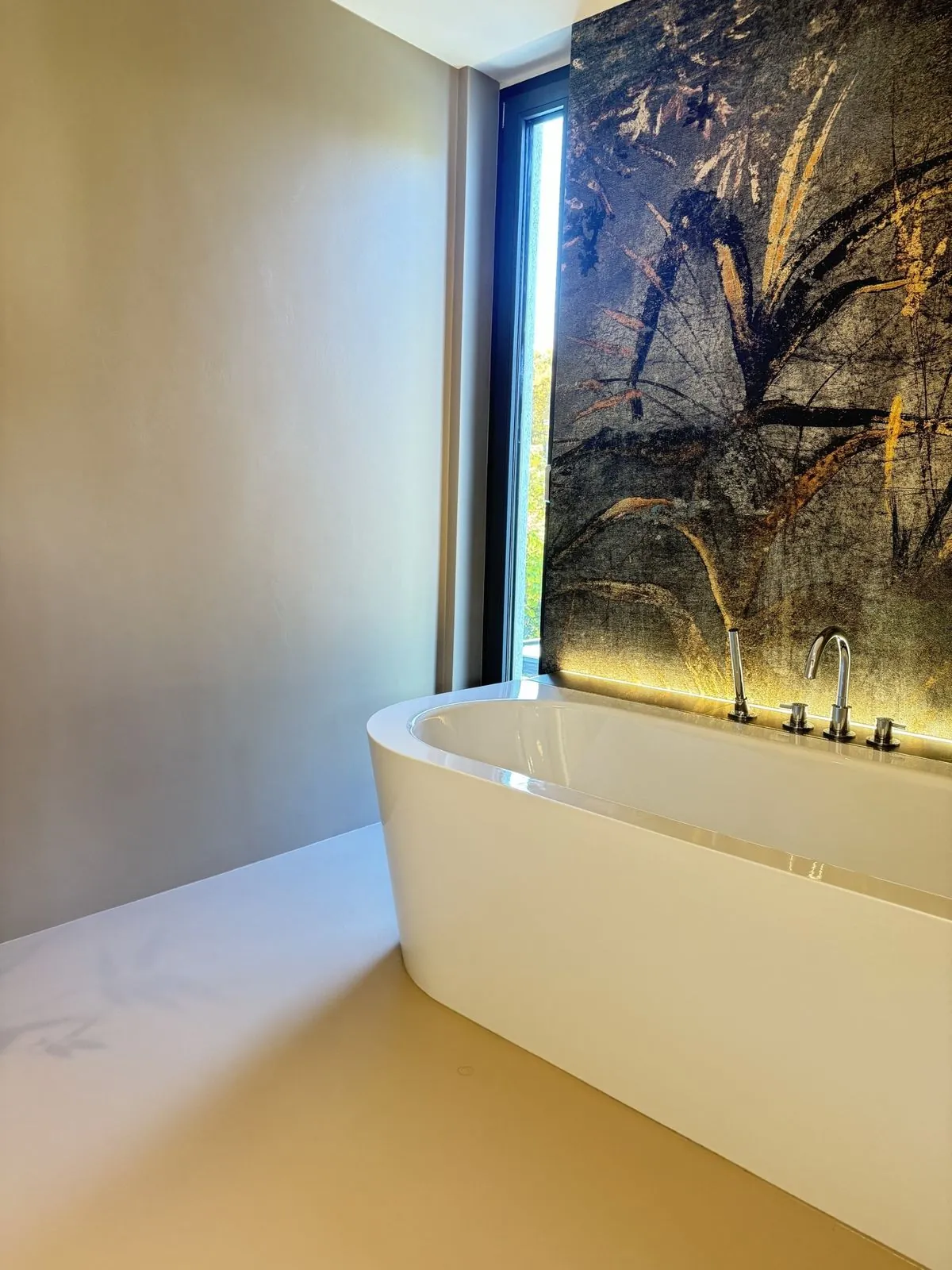 Badewanne vor beleuchteter Wand mit fugenloser Oberfläche